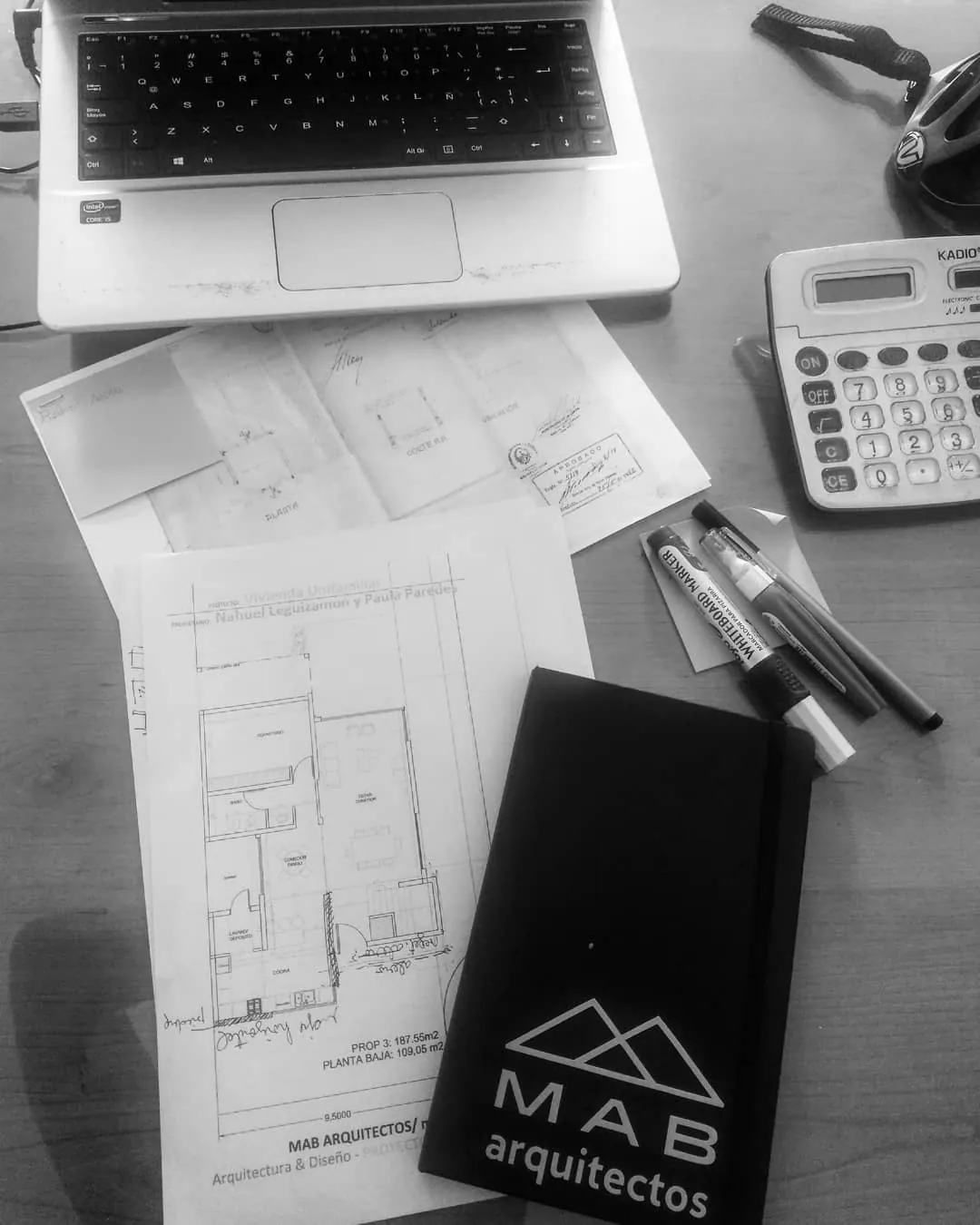 Planos y materiales sobre una mesa de trabajo del estudio